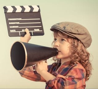 Child with megaphone and clapper board