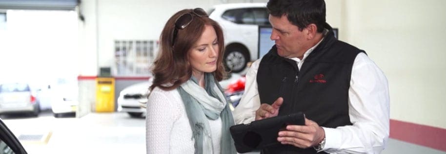 Automotive service adviser showing a customer information on an iPad