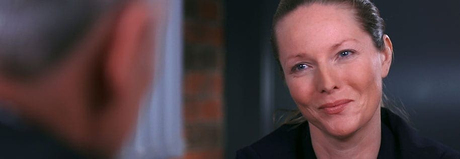 Close-up of a woman looking towards another person during a conversation.