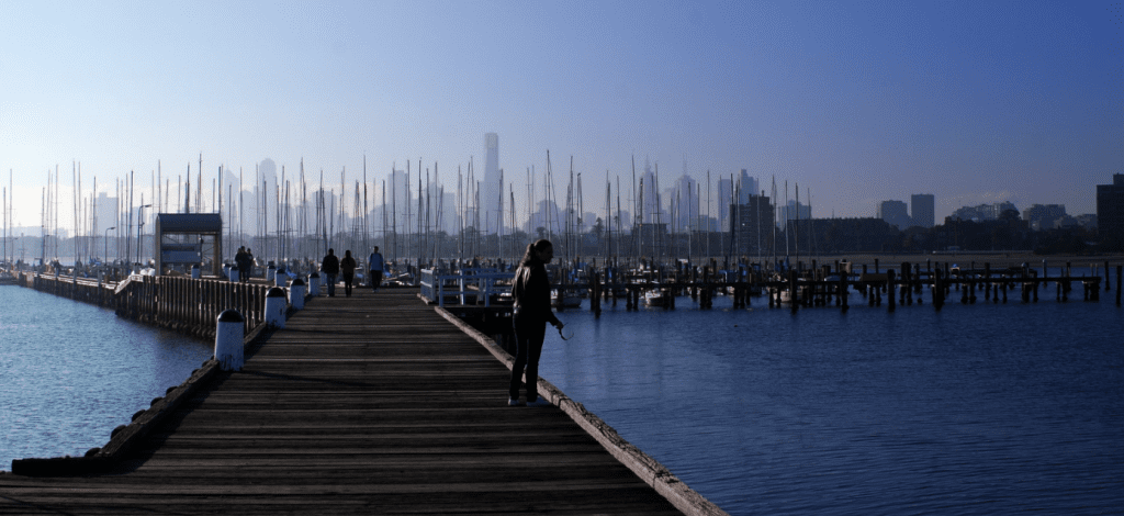 A historical view of a timber pier, marina and Melbourne skyline from the original 2018 article.