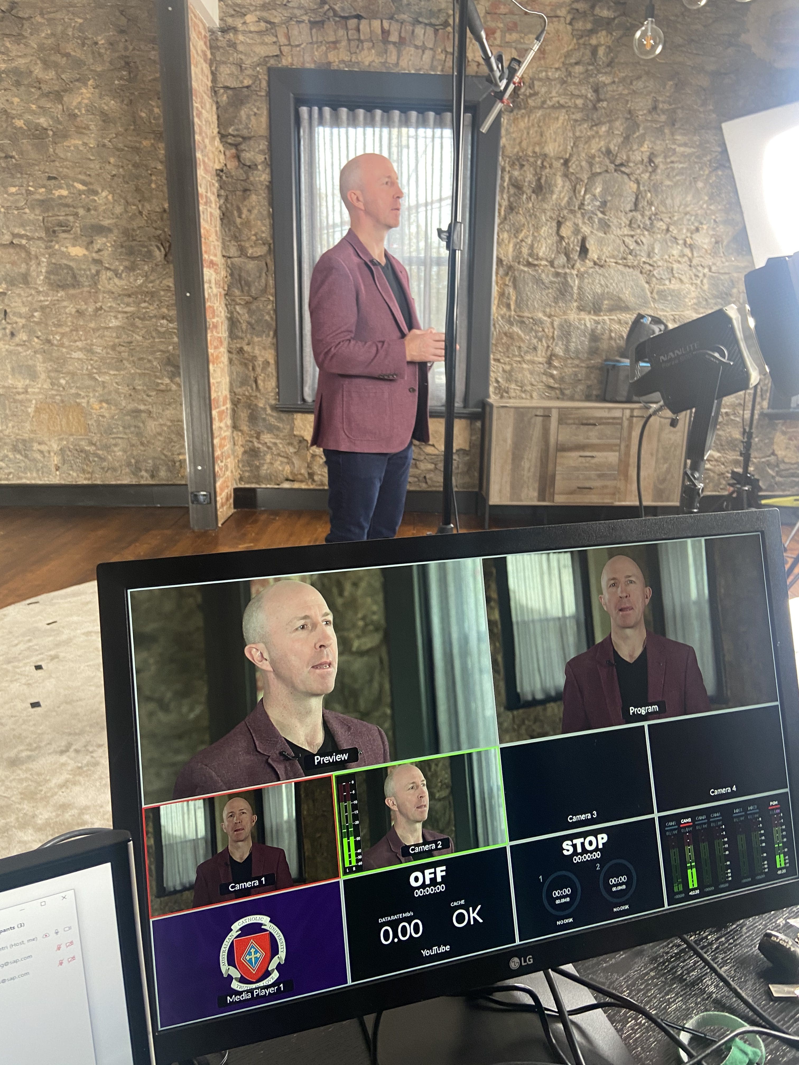 Male presenter being filmed by Dream Engine with his camera image visible on a production monitor