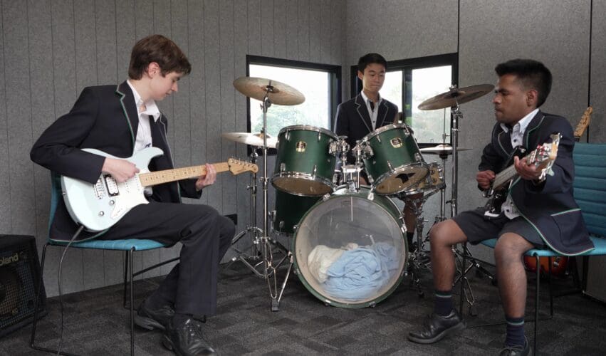 Three student musicians rehearsing inside a Harwyn music pod