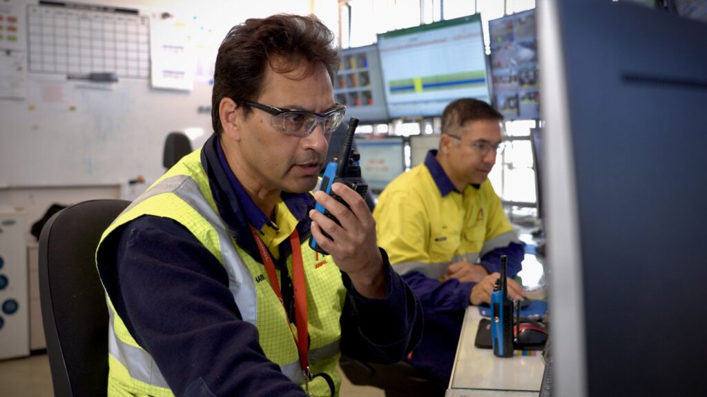 Worker speaking into a walkie talkie at an industrial site