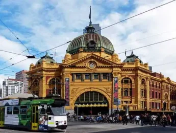 Flinders Street train station with tram passing.