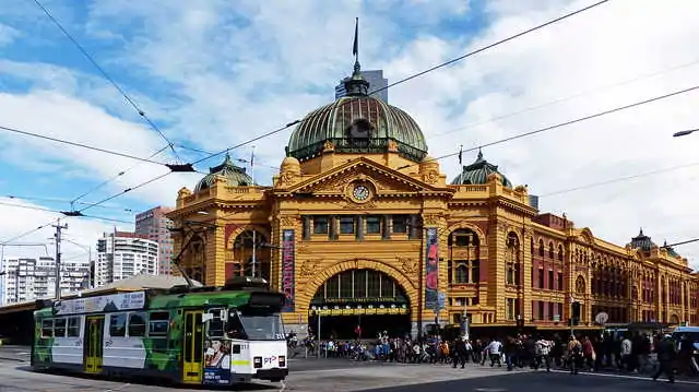 Flinders Street train station with tram passing.