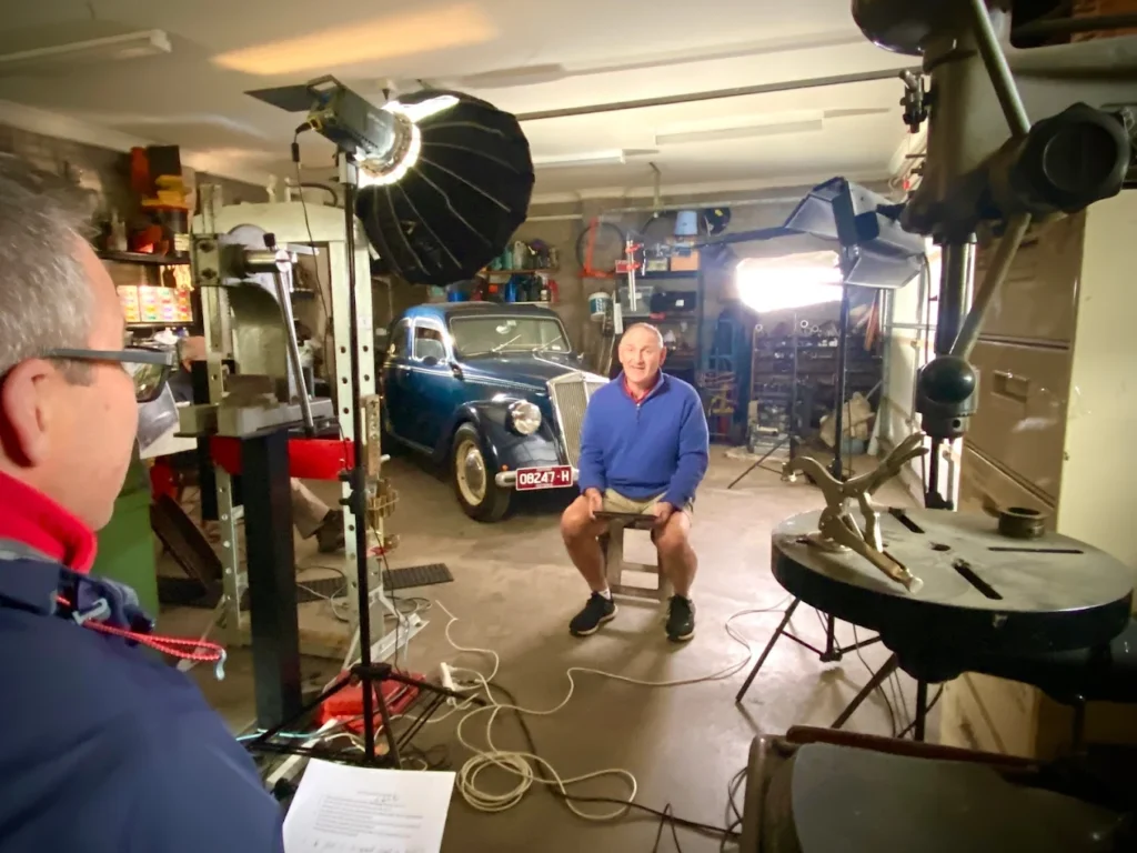 man being interviewed in front of a car