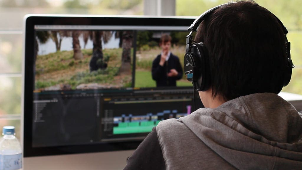 Dream Engine editor wearing headphones while reviewing a corporate video timeline