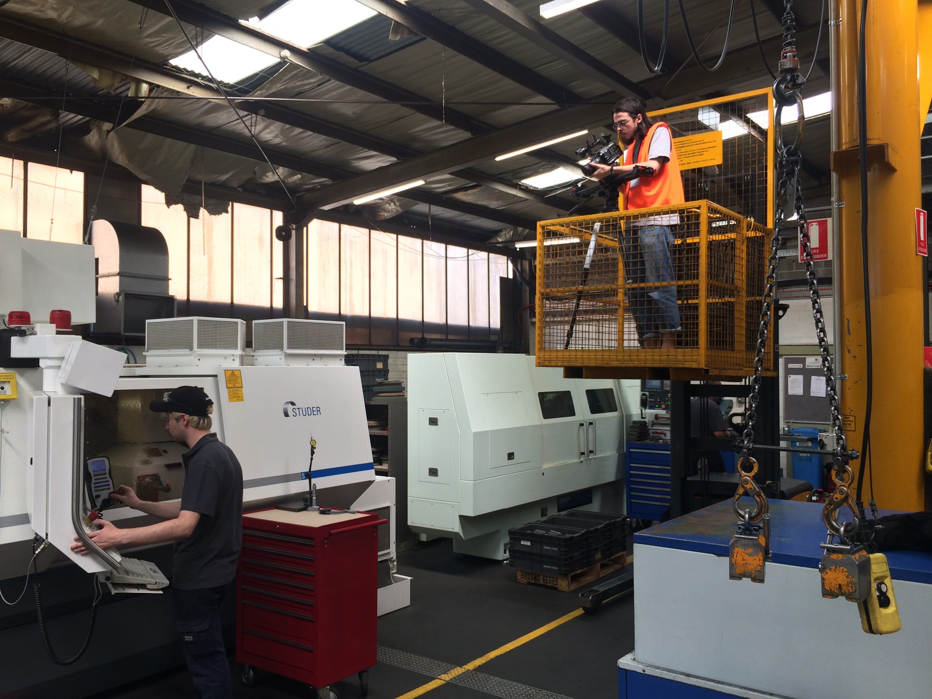Dream Engine camera operator filming safely from an elevated platform inside a manufacturing facility