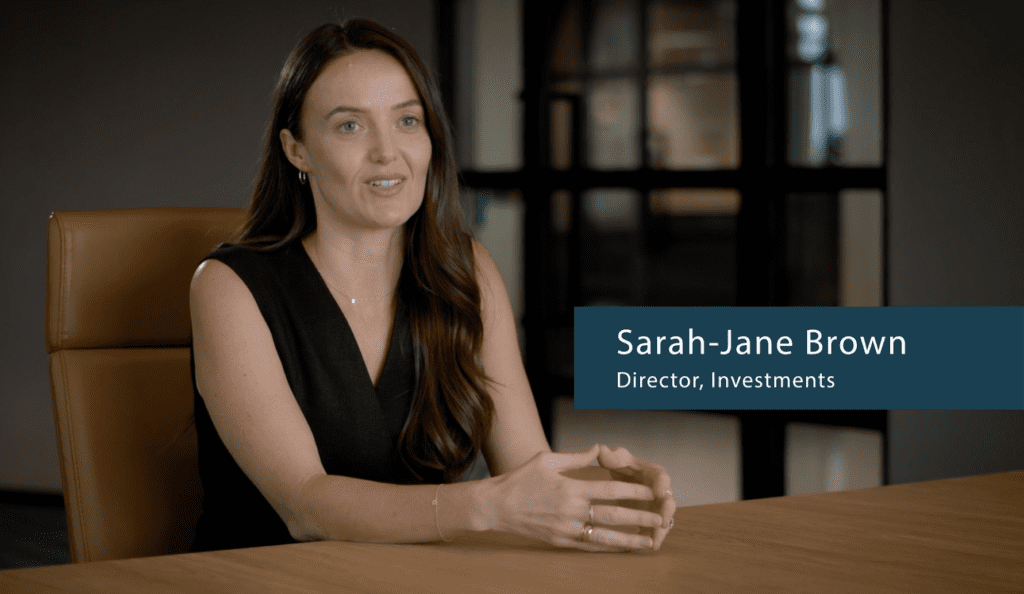 person at boardroom table being interviewed