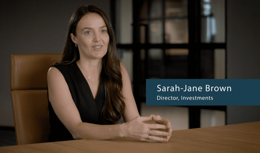 person at boardroom table being interviewed