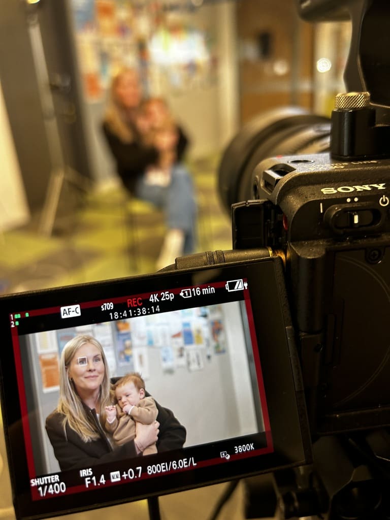 Sony camera filming a parent holding a baby at a City of Boroondara Maternal and Child Health centre