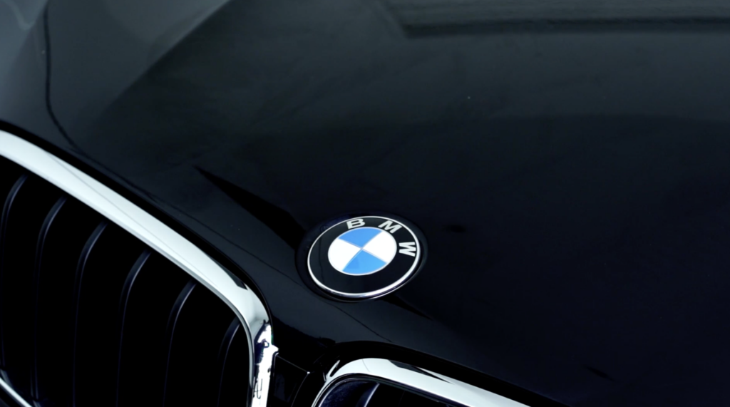 Close-up of BMW vehicle paintwork being inspected during automotive training video production