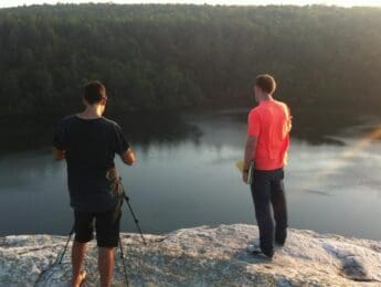 Two people filming above a lake at sunset during Dream Engine's USA production trip