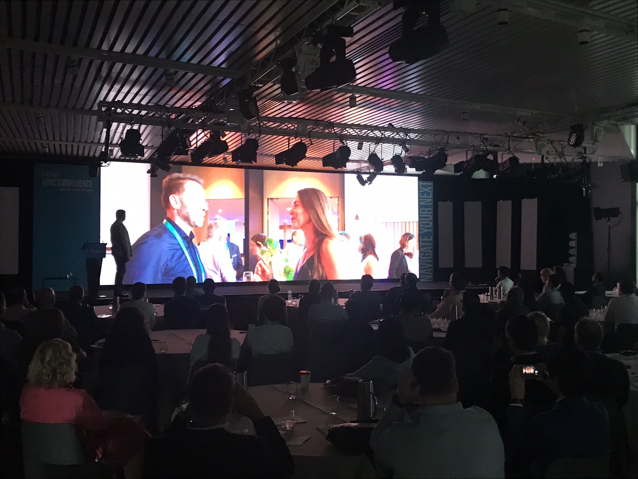 Infosys Confluence attendees watching the completed same-day highlights video on the main screen