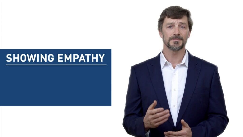 A presenter beside a blue graphic reading Showing Empathy.